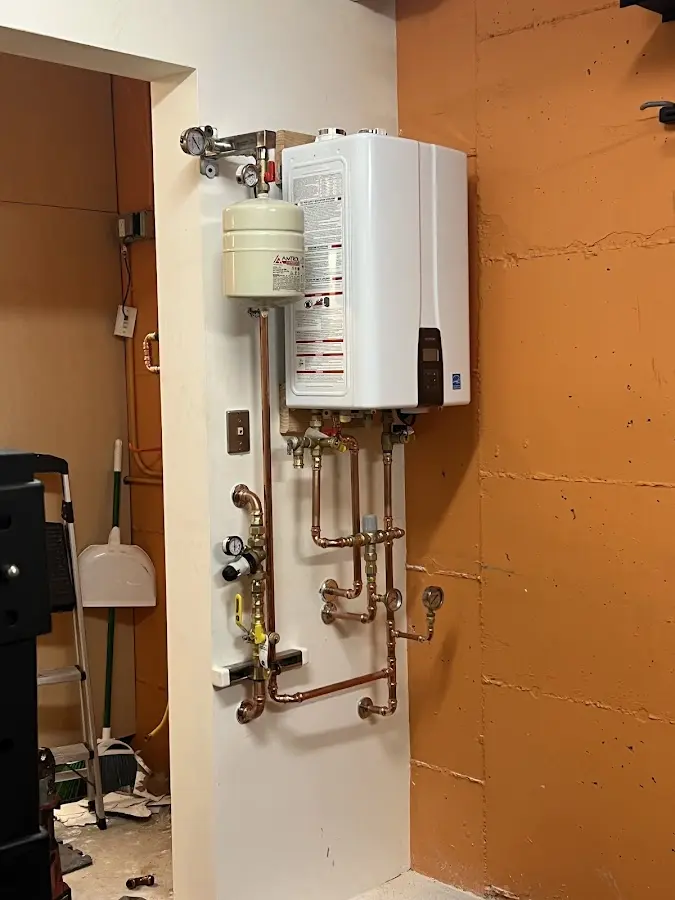 Plumbing technician inspecting water heater connections in Glendale